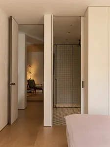 Cozy bedroom with a large white doorway, two chairs, and a couch, creating a comfortable seating arrangement