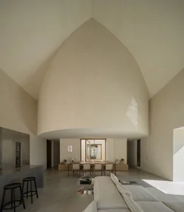 Open living space with cathedral ceiling, two couches, three chairs, and natural light from a window