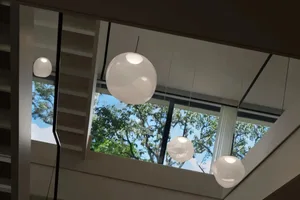 Open modern space with suspended lights, natural light, and two windows