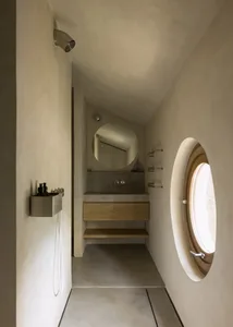 A modern bathroom with two sinks under a large mirror, a glass shower door, and white walls with grey tiles, creating a bright and inviting atmosphere