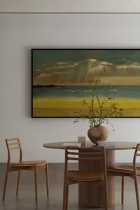 A serene beach scene with sandy shore, ocean waves, and several chairs and a potted plant set against a white background