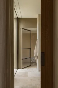 Clean and well-organized bathroom with a glass shower door, a large mirror, and two towels hanging on the sides