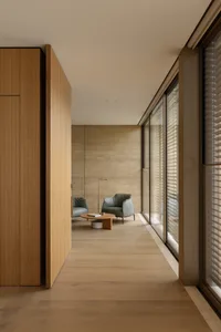 Open living area with wooden walls, a dining table, and natural light from windows