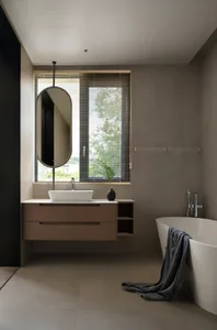 Bathroom with a sink, mirror, and bathtub, featuring two windows and a potted plant