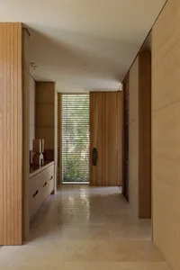 A warm and inviting interior hallway with wooden walls and floors, featuring two doors and possibly natural or artificial lighting
