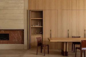 A modern dining space with a wooden table and chairs, surrounded by a warm and inviting atmosphere created by natural materials