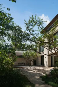 A traditional house with a brick facade and a patio area featuring two benches, creating a calm and inviting atmosphere for relaxation and socializing
