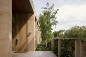 A modern house with multiple rooms, concrete walls, large windows, and potted plants, conveying a sense of luxury and sophistication