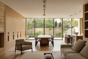 A well-lit open concept living area with a dining table and chairs, a couch, and natural light from windows