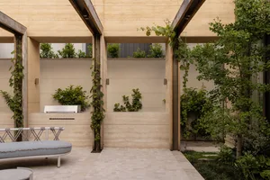 A patio dining area with a table and chairs surrounded by potted plants, creating a relaxing and inviting atmosphere