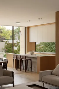 Open modern kitchen and living area with wooden cabinets, comfortable seating, and a harmonious blend of spaces