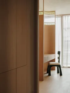 Small room with wooden walls and floors, featuring a desk between two chairs, creating a warm and inviting workspace
