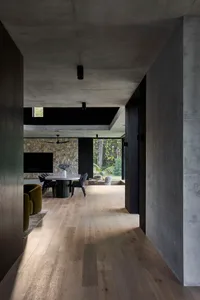 Cozy modern living space with a dining table, chairs, and a couch, featuring a warm and inviting atmosphere