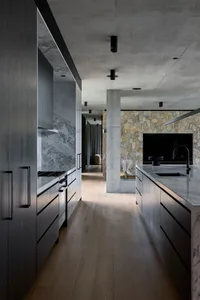 Open modern living space with a kitchen island, wooden flooring, a couch, TV, and dining table