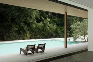 A serene poolside area with two wooden chairs placed near the pool, inviting relaxation and socializing