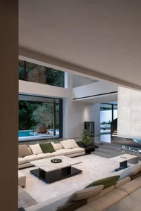 Bright and inviting open living area with a white couch, chairs, dining table, and potted plants, surrounded by glass doors leading to a pool