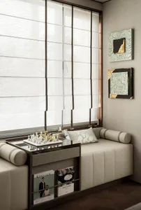Cozy living space with a couch, chairs, dining table, and books, surrounded by large windows and natural light