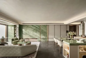 Open modern living space with a large marble wall, two couches, a dining table, chairs, and a potted plant, featuring luxurious materials and stylish furnishings