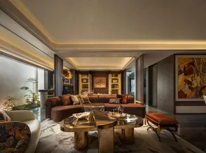 Cozy living space with a brown leather sofa, two chairs, and a dining table, designed for relaxation and socializing