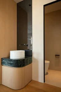 Modern bathroom with two sinks, a toilet, and a mirror, featuring a clean and bright white-painted space