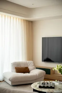 Cozy living room with a couch, TV, and vases, creating a warm and inviting atmosphere