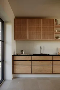 Warm and inviting kitchen with wooden cabinets, two sinks, and various kitchen items on countertops