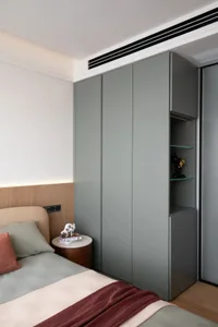 Cozy bedroom with a gray color scheme, featuring a bed, dresser, chairs, and a small table, with dim lighting