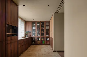 Clean and organized kitchen with wooden cabinets, tile flooring, and various kitchen items on display