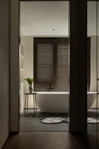 Bathroom with a white bathtub next to a window, featuring two vases and a calm atmosphere with natural light