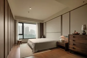 Cozy bedroom with a white bed in front of a window, wooden floor, and two chairs on either side