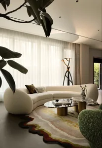 Cozy living room with a white couch, potted plants, a vase, and a chair, set against a neutral background