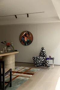 溫馨現代客廳，配有椅子、餐桌、沙發、花瓶、大型壁鐘與木質家具