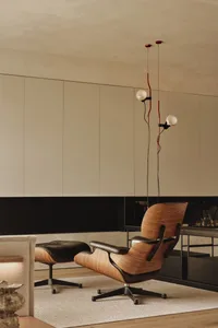 Modern living room with a gray wall, black countertop, and industrial-style furniture with red wires and a black chair
