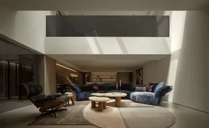 A modern living area with a couch, dining table, chair, and potted plant, well lit with natural sunlight or artificial lighting