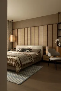 Cozy bedroom with a large bed, two chairs, a lamp, and a vase, featuring brown furniture and a white comforter