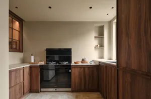 Warm kitchen with wooden cabinets, a black oven, and kitchenware on the countertop