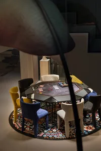 A dining area with a colorful mix of chairs surrounding a central table, creating a warm and inviting atmosphere
