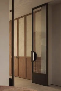 A calm and inviting interior hallway with a wooden door and a glimpse of the hallway beyond
