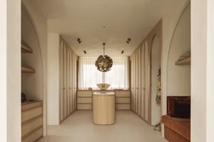 Bathroom with wooden floors and walls, natural light, and a chandelier, creating a clean and inviting atmosphere