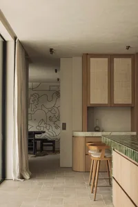 Warm and inviting kitchen dining area with wooden floors and cabinets, featuring a dining table and chairs, and decorative vase on the countertop