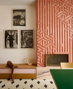 Cozy living area with a pink accent wall, a green table, and a comfortable seating arrangement with a couch and chair