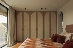 Cozy bedroom with a large bed, two wooden wardrobes, and dim lighting