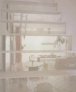 A modern staircase in a white house with a potted plant and two bottles, conveying simplicity and cleanliness