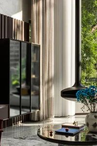 Cozy living space with a black TV mounted on the wall, surrounded by vases and potted plants