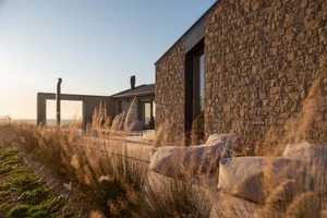 A relaxing outdoor living space with two couches and two chairs on a patio, surrounded by natural surroundings