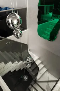 大理石階梯的豪華樓梯，搭配天花板懸掛三個大型玻璃或水晶球體的獨特裝置藝術