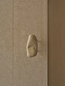 A stone doorway with a rock embedded into its surface, complemented by wooden elements, creating a charming rustic atmosphere