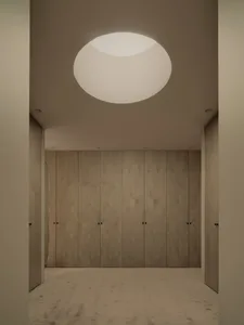 Empty room with wooden walls and ceiling, two doors, and a warm and cozy atmosphere