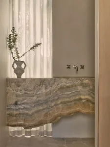 Bathroom with two sinks, marble countertop, and a potted plant near the left sink