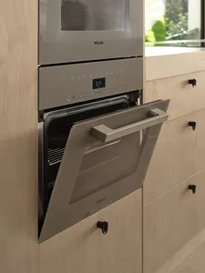 Kitchen with stainless steel oven, open door, drawers, and a potted plant near the edge